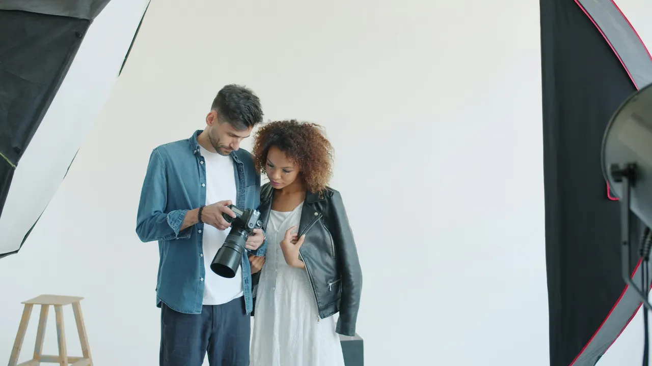 Un formateur et une élève regardent ensemble l'écran d'un appareil
