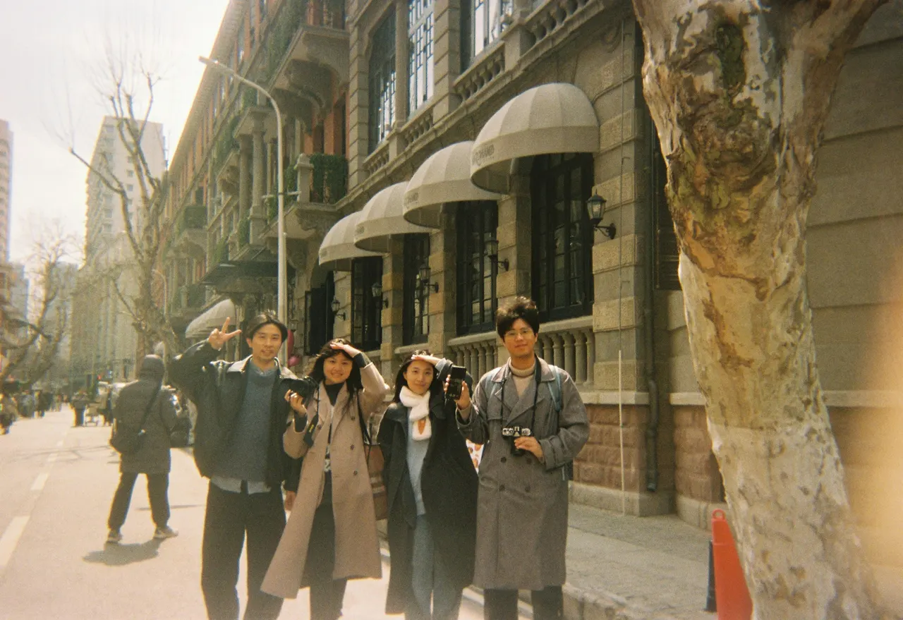 Un petit groupe photographie dans une rue à la lumière ambrée