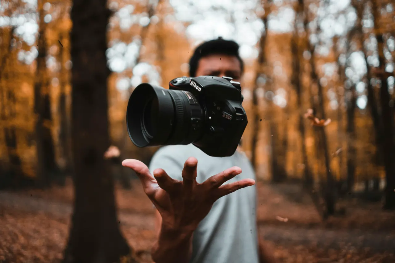 Une main règle un reflex dans la lumière d'automne
